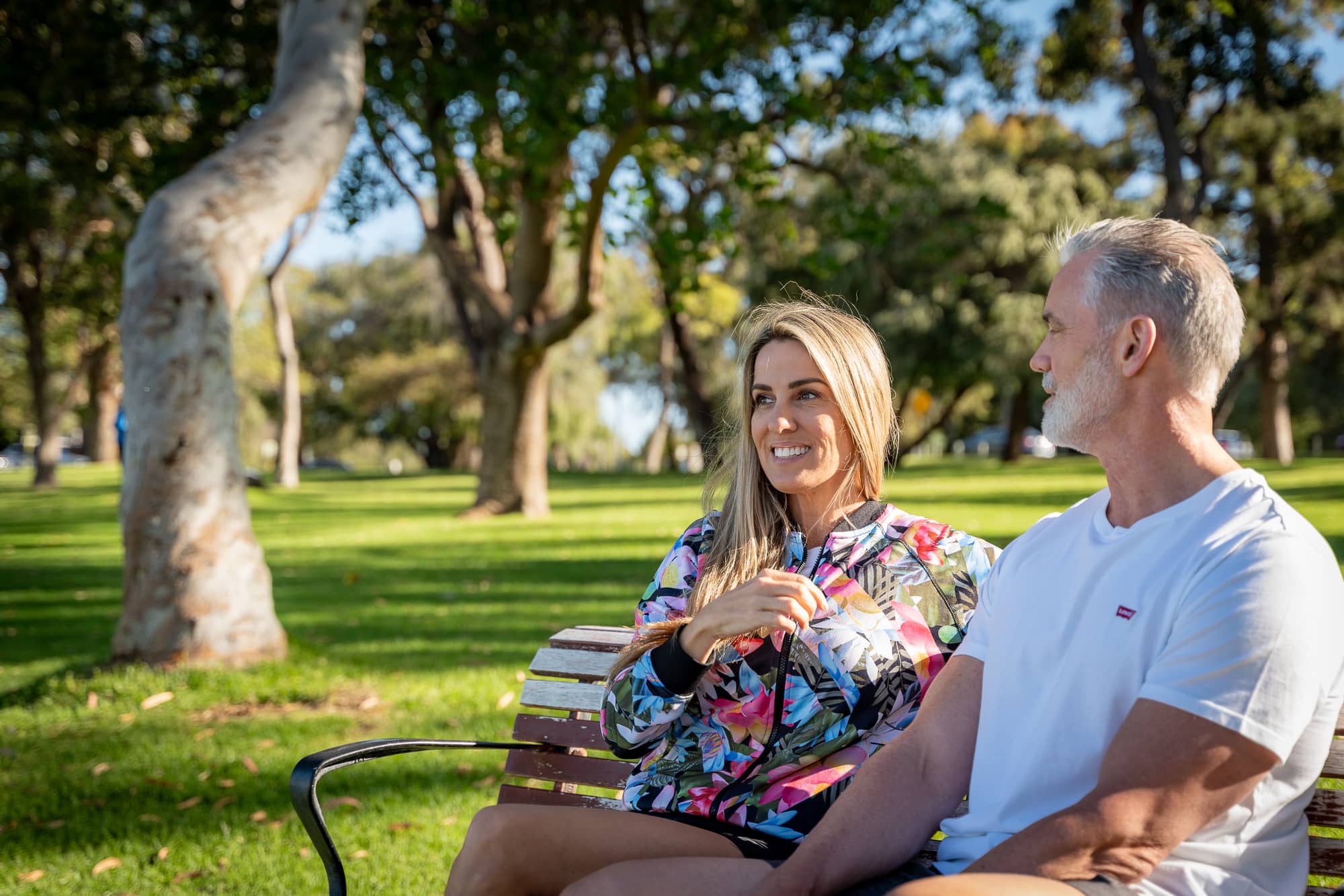 man and woman sitting on bench smiling