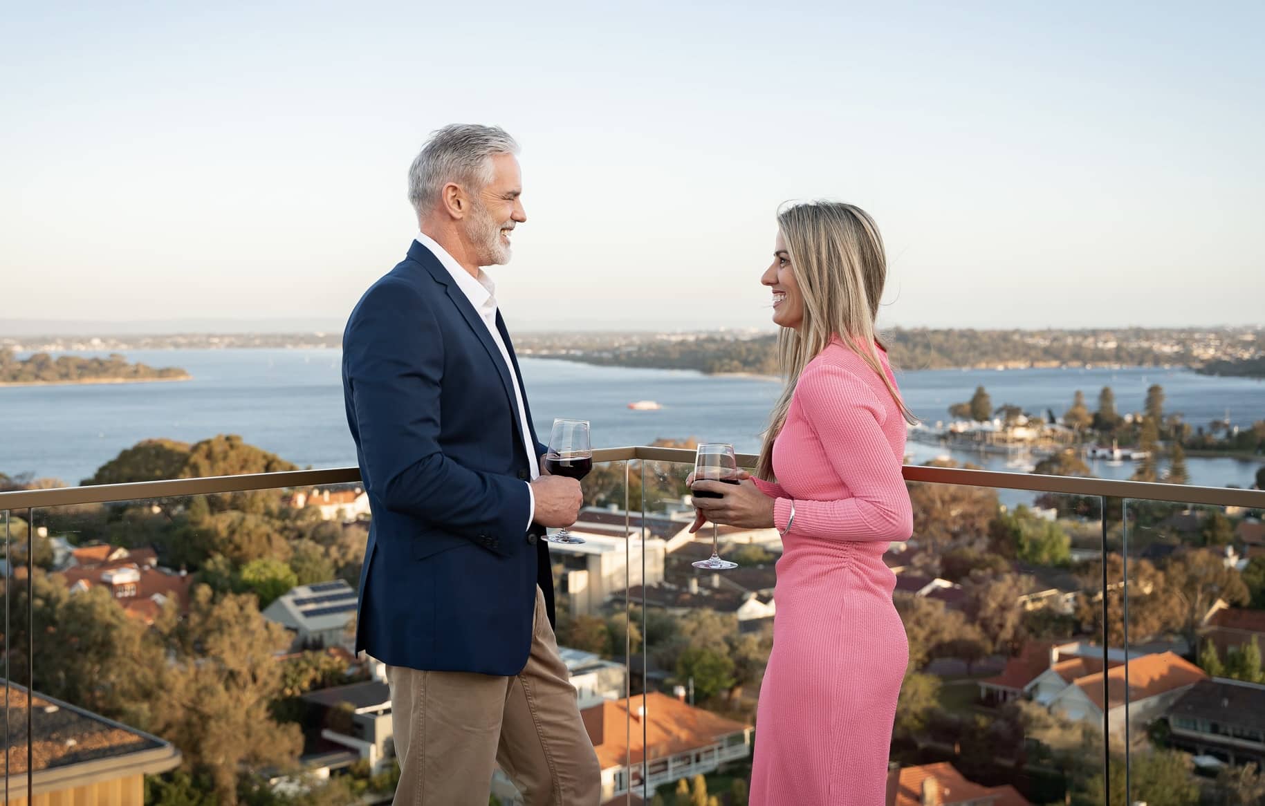 man and woman have a drink on balcony